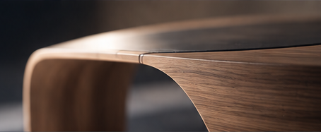Close-up of precisely shaped wood furniture with a curved edge.